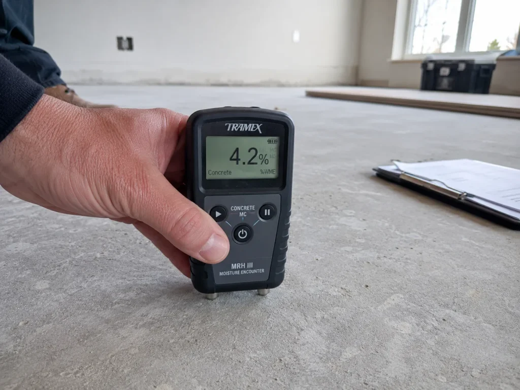 Moisture meter testing a concrete subfloor before flooring installation in Ireland.